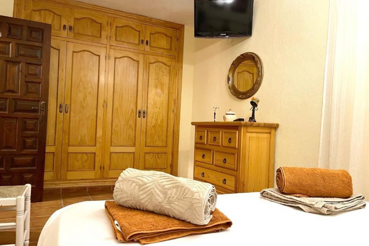 Dormitorio preparado con toallas dobladas sobre la cama